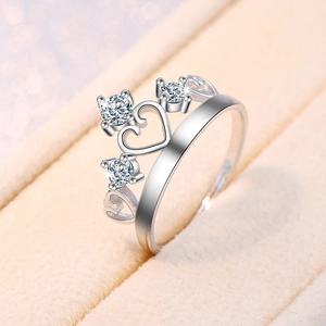Detailed macro view of silver crown ring featuring three sparkling zircons and heart cutouts