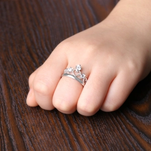 Macro shot of silver crown ring with heart motifs and three brilliant-cut zircons on hand