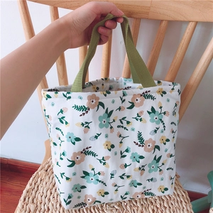 Detail der floralen Canvas-Lunchtasche mit grünen Griffen und Reißverschluss