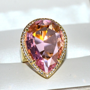 Luxurious gold teardrop ring featuring a pear-cut pink crystal and halo of clear stones