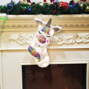 Detail of unicorn Christmas stocking with sequins hanging on a decorated festive fireplace