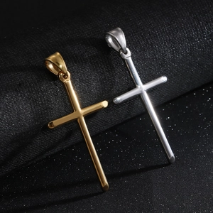 Minimalist gold and silver stainless steel cross pendants on a dark textured background