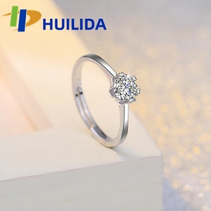 Macro shot of silver adjustable ring with a brilliant round-cut zircon in 6-prong flower setting
