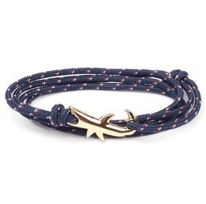 Macro detail of navy braided nylon bracelet with gold shark hook clasp on white background