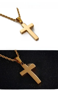 Gros plan détaillé d'un pendentif croix dorée polie avec une chaîne de style corde