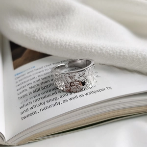 Detailed view of 925 sterling silver ring with irregular moon texture on book pages