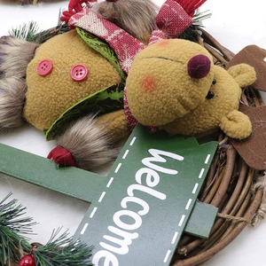 Christmas wreath featuring a plush reindeer and Welcome sign on a natural rattan base