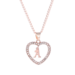 Détail d'un pendentif cœur en or rose avec la lettre A et cristaux scintillants
