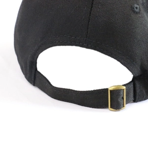 Detail of black baseball cap showing the adjustable metal buckle and fabric strap closure