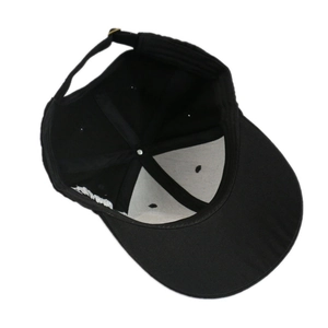 Detail of black baseball cap interior showing white front lining and adjustable metal buckle