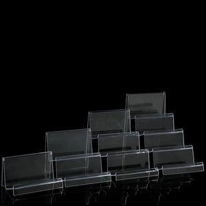 Set of clear acrylic display stands for wallets and phones on black background