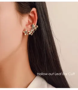 Detail of vintage hollow leaf gold ear cuff clip worn by a model for non-pierced ears