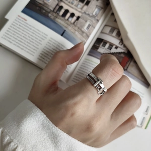Macro shot of 925 silver belt buckle ring with hanging circle on a fashion magazine