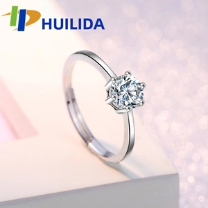 Macro shot of silver six-prong engagement ring featuring a sparkling brilliant round stone