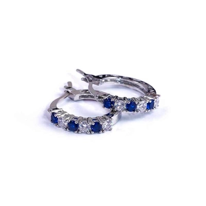 Detail of silver hoop earrings with alternating blue and white cubic zirconia stones