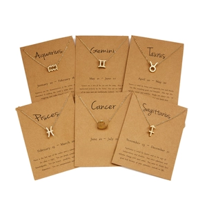 Close-up of gold constellation necklaces set on display cards with crystal details