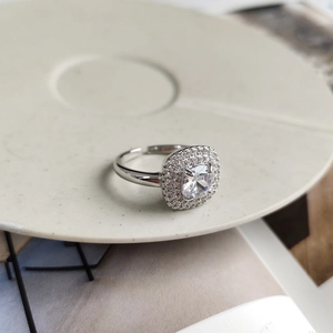 Detail of square zircon halo ring on a ceramic tray with light luxury silver finish