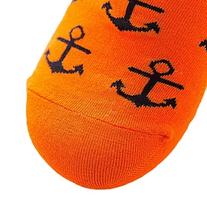 Macro view of orange knitted socks featuring black anchor patterns and seamless toe detail