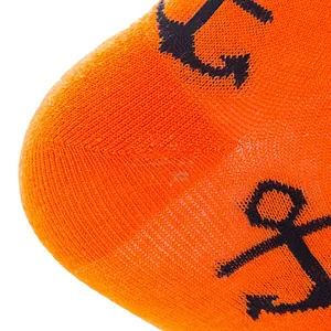 Close-up of orange cotton socks featuring a detailed navy blue anchor knit pattern