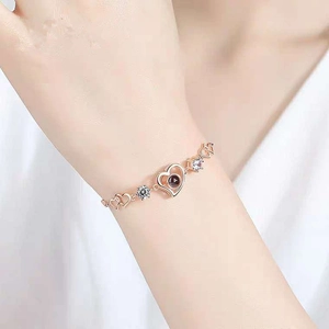 Rose gold heart projection bracelet with sparkling crystal accents worn on a wrist