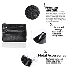 Detail view of black lychee leather coin purse featuring three zippers and silver keychain