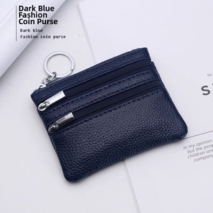 Detail of dark blue litchi grain leather coin purse with double zipper and silver keyring
