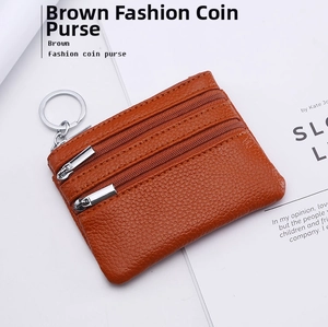 Detail view of brown pebbled leather coin purse with double zippers and metal keychain