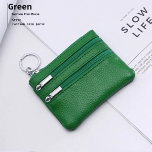Macro shot of green pebble leather coin purse featuring dual zippers and metal keychain