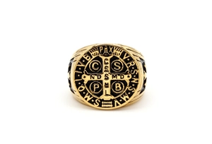 Detail of Saint Benedict medal ring in gold and black steel with religious symbols