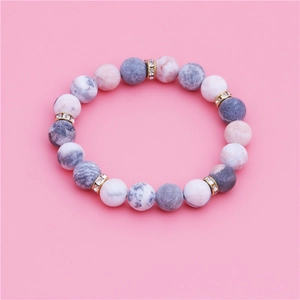 10mm matte pink marble stone beaded bracelet with gold rhinestone spacers on pink background