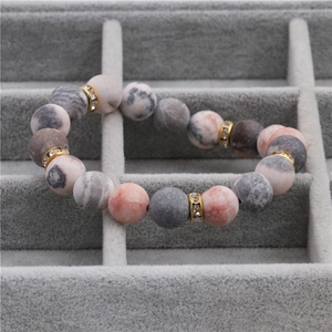 10mm matte pink spotted stone beaded bracelet with gold rhinestone spacers on velvet