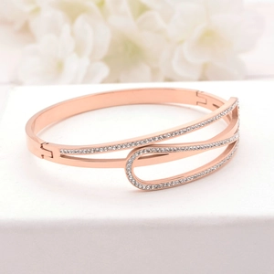 Rose gold stainless steel geometric bracelet with sparkling diamond inlay on white floral backdrop