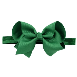 Detail of a large handmade green grosgrain ribbon bow on a high-elastic baby headband