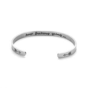 Close-up of titanium steel cuff bracelet with 'keep fucking going' engraving inside.
