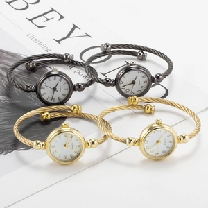 Macro shot of stylish bangle watches in gold and charcoal tones with quartz movement