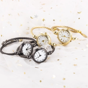 Detailed display of assorted bangle watches with quartz movement on star patterned gauze