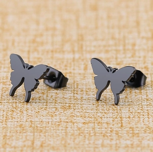 Boucles d'oreilles papillon minimalistes en acier inoxydable noir mat sur fond beige