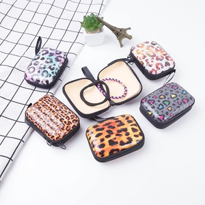 Detail of square tinplate coin purse featuring leopard prints and internal mesh pocket