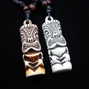 Detail of carved resin Tiki pendants in beige and antique brown with woven black rope cords