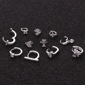 Silver cartilage piercing set with micro-pave zircons on a textured black background