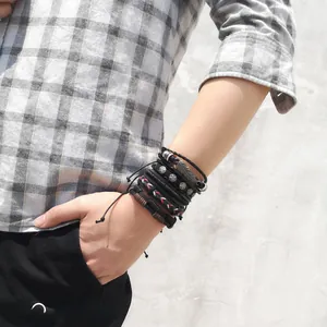 Close-up of multilayer leather bracelet set with feather pendant and star studs