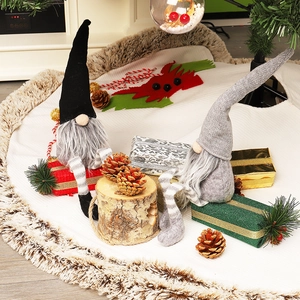Detail of grey and black knit Christmas gnomes with white faux fur tree skirt decor