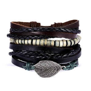 Detail showing multilayer leather bracelets with wooden beads and engraved leaf charm
