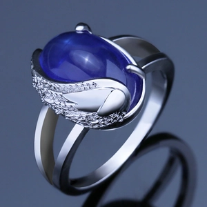 Silver angel wing ring with large oval blue sapphire stone and white diamond accents
