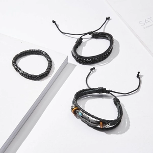 Detail of three-piece black vintage men's leather bracelets with feather and turquoise bead
