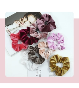 Lot de 9 chouchous en velours de couleurs variées posés sur un magazine de mode chic