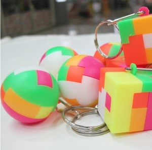 Macro view of colorful 3D puzzle keychains in spherical and cubic shapes with metal rings