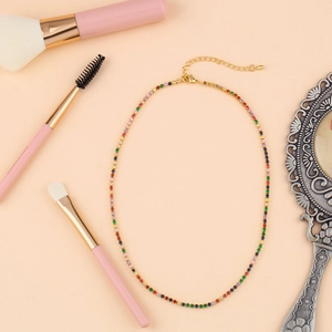 Detailed shot of a rainbow zircon choker with gold setting on a dressing table