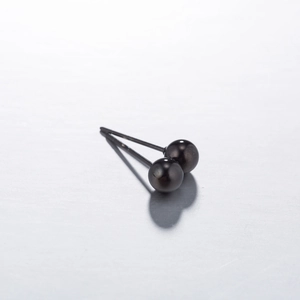 Close-up detail of smooth black stainless steel ball stud earrings with polished finish
