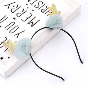 Close-up of gray-blue pom poms and golden glitter antlers on a Christmas reindeer headband